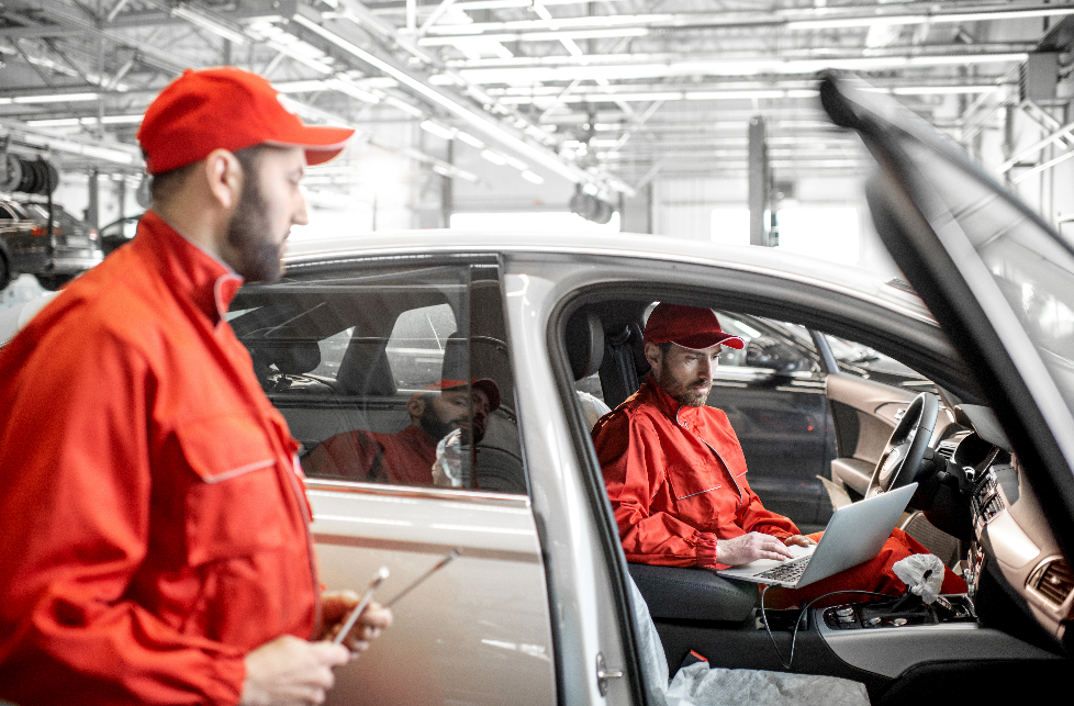 Mécanicien automobile diagnostiquant une voiture avec ordinateur